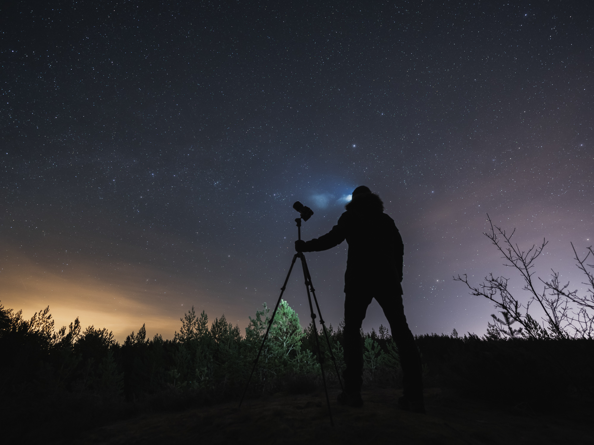 Photographer standing near camera under the Milky Way