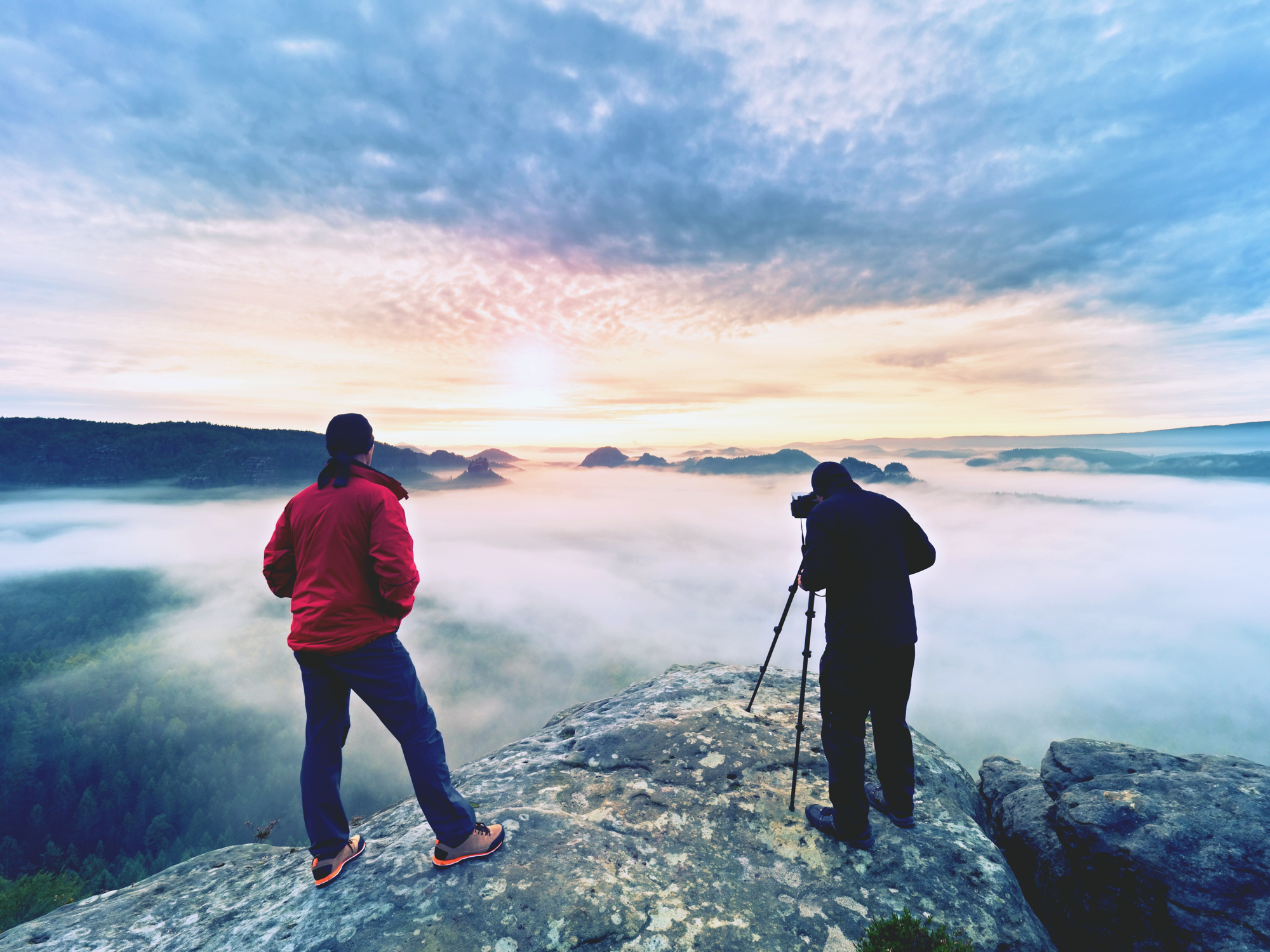 People standing on rocks taking pictures